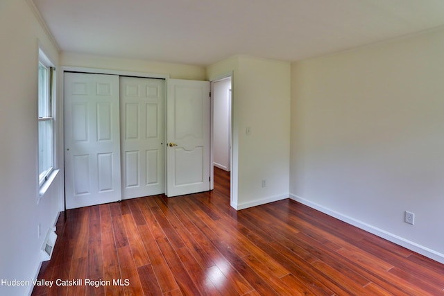 unfurnished bedroom featuring dark hardwood / wood-style floors and a closet