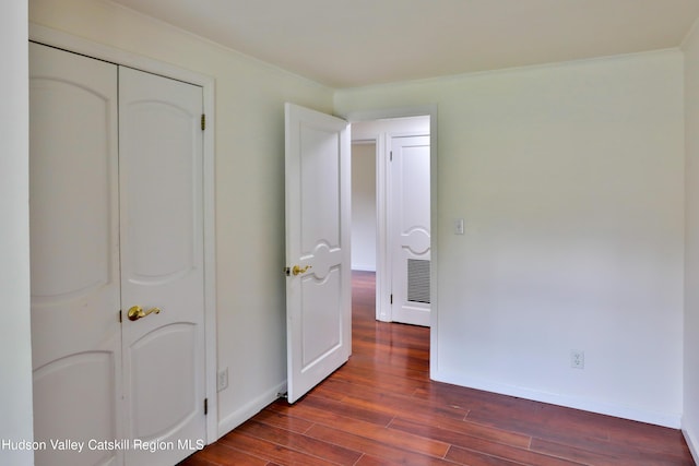 bedroom featuring dark hardwood / wood-style flooring, a closet, and ornamental molding