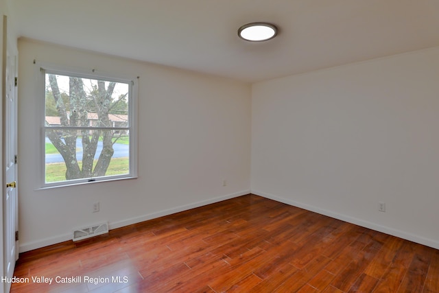 unfurnished room with wood-type flooring