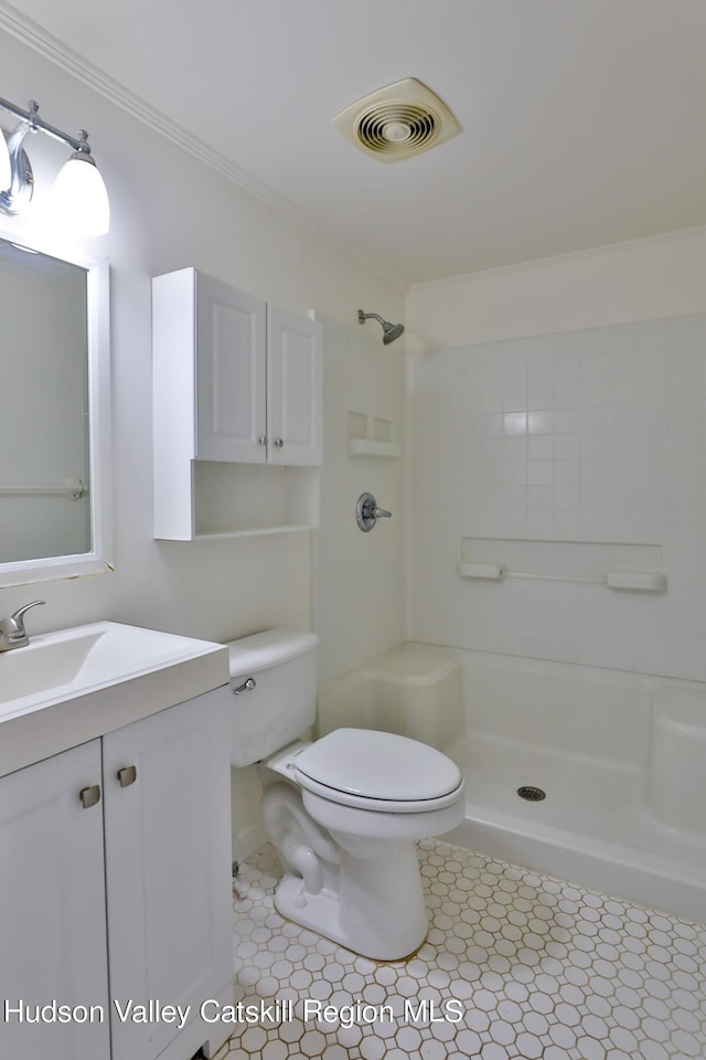 bathroom with tile patterned floors, vanity, toilet, and walk in shower