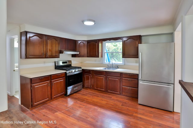 kitchen featuring stainless steel appliances, dark wood-type flooring, and sink