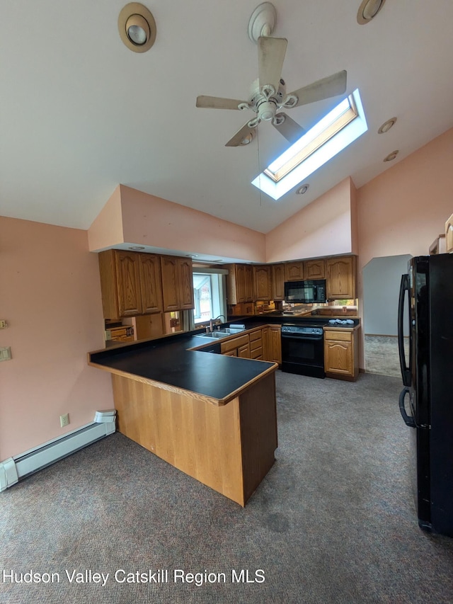 kitchen with lofted ceiling with skylight, black appliances, sink, baseboard heating, and kitchen peninsula