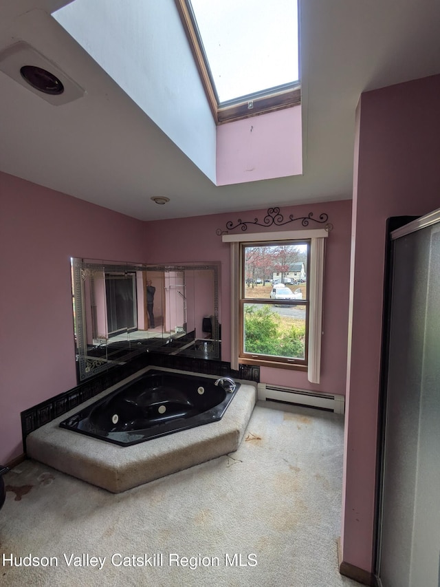 bathroom with a washtub, a baseboard radiator, and vaulted ceiling with skylight