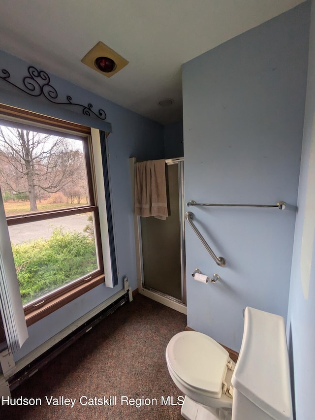 bathroom featuring a healthy amount of sunlight, an enclosed shower, and toilet