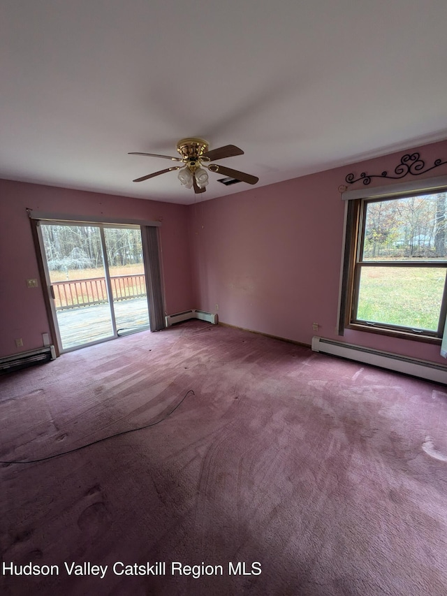 carpeted empty room with ceiling fan and a baseboard heating unit