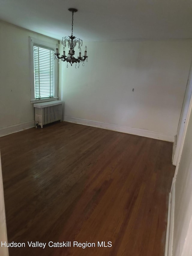 unfurnished dining area with radiator, dark wood-type flooring, and a notable chandelier