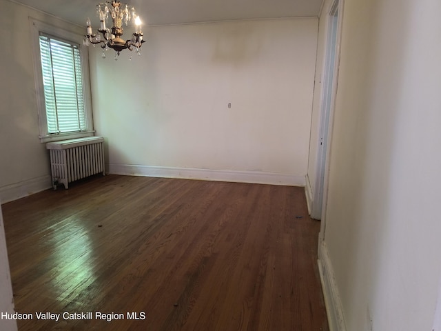 unfurnished dining area featuring dark hardwood / wood-style flooring, radiator, and a chandelier