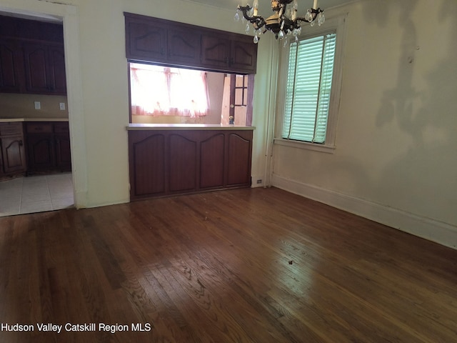 unfurnished dining area featuring hardwood / wood-style floors and a chandelier