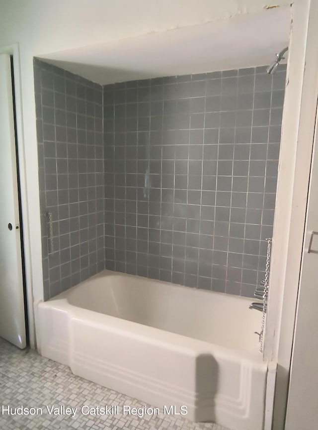 bathroom featuring tiled shower / bath combo and tile patterned floors