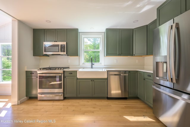 11351 State Rte 22, Austerlitz, NY 12017 - kitchen with green cabinets, stainless steel appliances, a sink, and light countertops