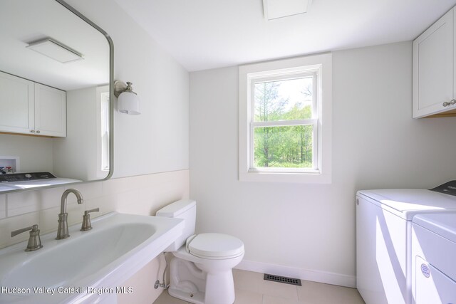 11351 State Rte 22, Austerlitz, NY 12017 - bathroom featuring washer and clothes dryer, a sink, toilet, baseboards, and tile patterned flooring