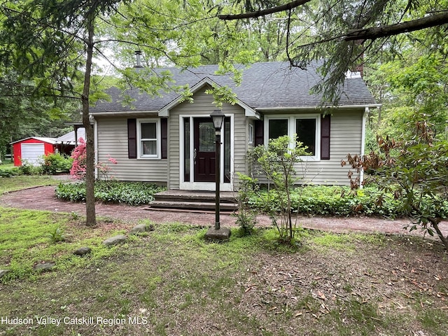 89 Bloomingdale Rd, Tillson, NY 12486 - view of front of house with a shingled roof, an outbuilding, and a chimney