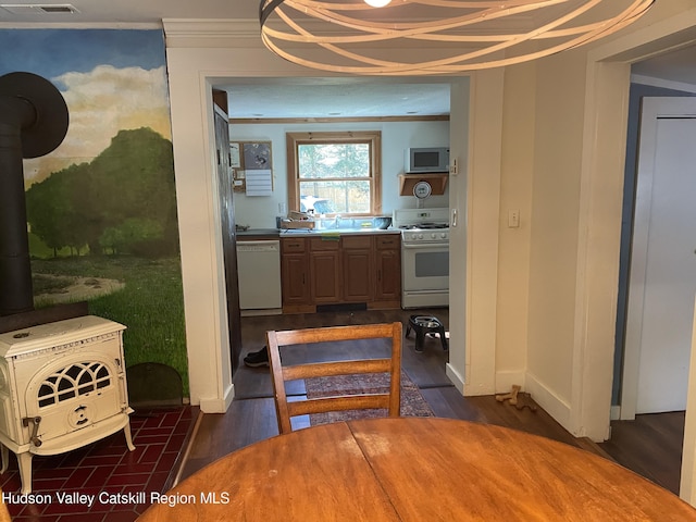 89 Bloomingdale Rd, Tillson, NY 12486 - kitchen with white appliances, a wood stove, a sink, dark wood-type flooring, and baseboards