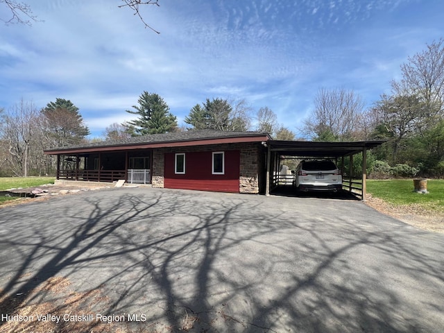 296 Circle Rd, Cragsmoor, NY 12420 - view of front of house with driveway, stone siding, and an attached carport