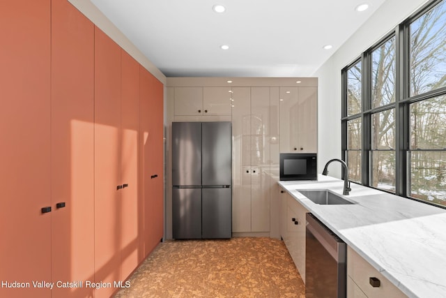 kitchen featuring stainless steel appliances, light stone countertops, sink, and white cabinets