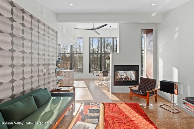 living room with a multi sided fireplace and ceiling fan