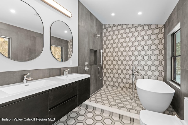 bathroom with tile walls, vanity, tile patterned floors, and separate shower and tub