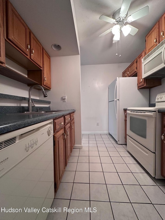 kitchen with ceiling fan, sink, white appliances, and light tile patterned floors