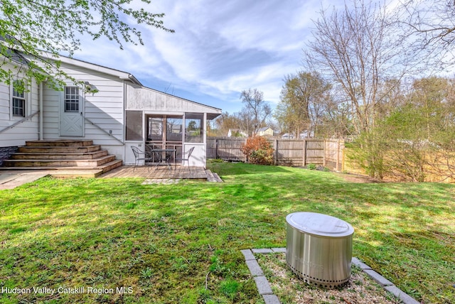 view of yard featuring entry steps, a sunroom, and fence