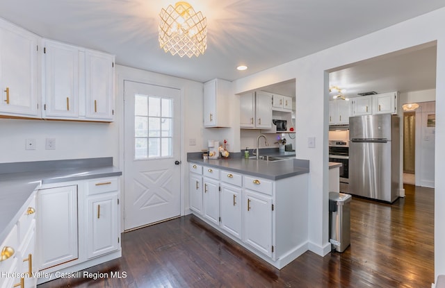 kitchen with a sink, dark wood-style flooring, freestanding refrigerator, white cabinetry, and range