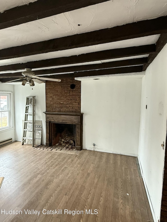 11 N Montgomery St, Athens, NY 12015 - unfurnished living room featuring beam ceiling, ceiling fan, a brick fireplace, and wood finished floors