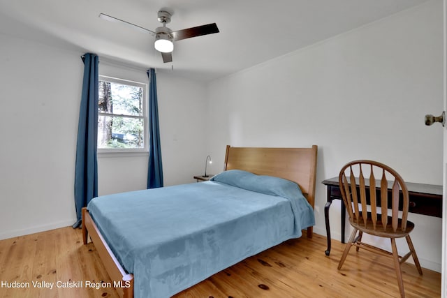 bedroom with baseboards, a ceiling fan, and light wood finished floors