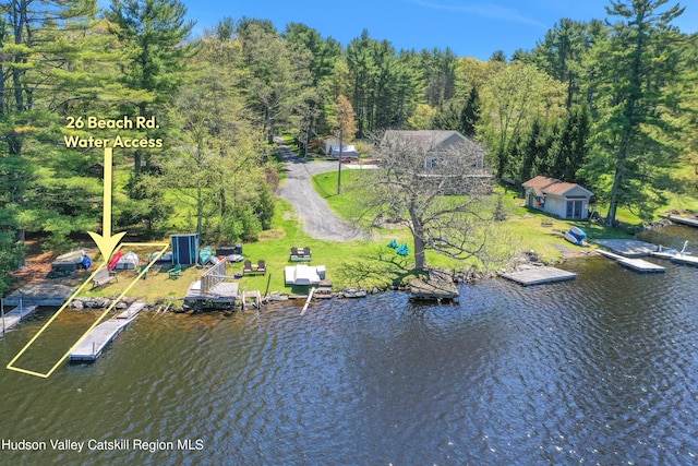 drone / aerial view featuring a water view and a wooded view