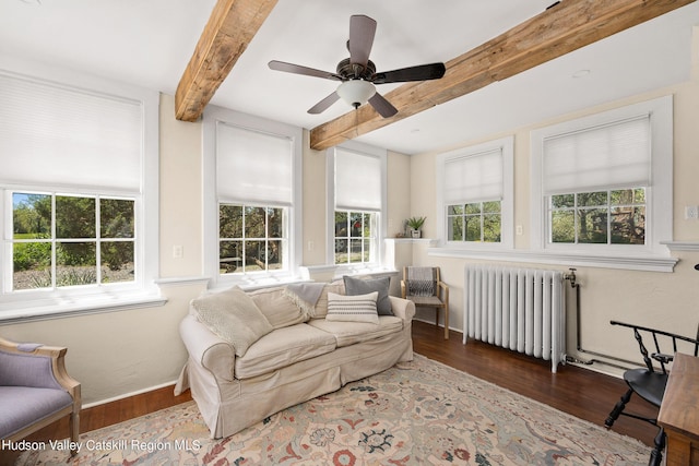 sunroom featuring beamed ceiling, ceiling fan, and radiator heating unit