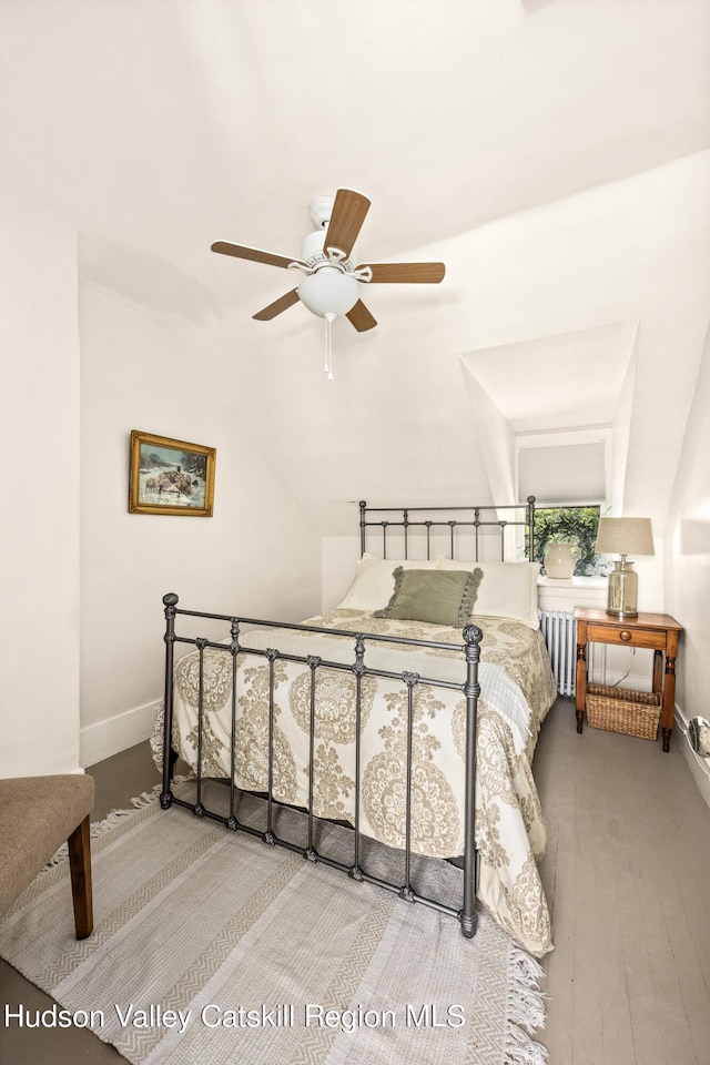 bedroom with ceiling fan, light wood-type flooring, and vaulted ceiling