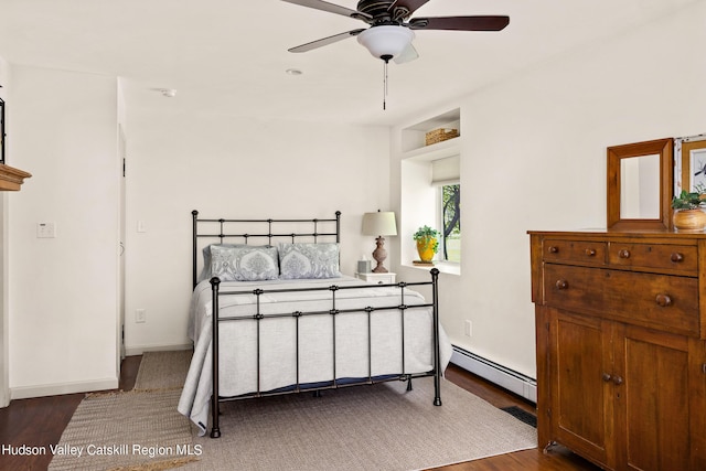 bedroom with ceiling fan, dark hardwood / wood-style flooring, and a baseboard radiator