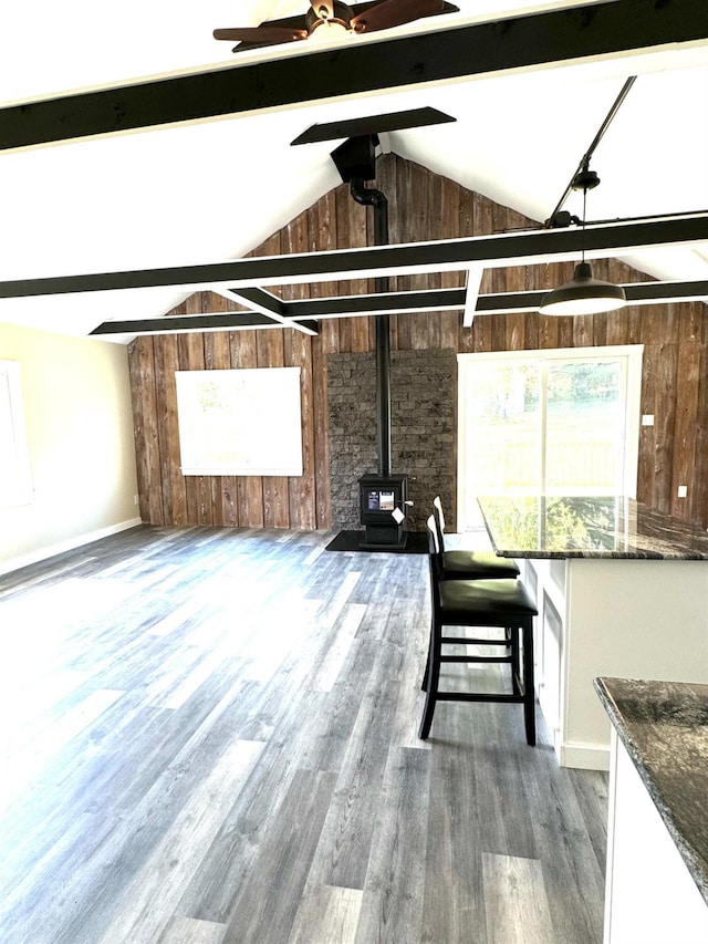 369 Newry Ln, Greenville, NY 12083 - interior space with a wood stove, wood walls, wood finished floors, a ceiling fan, and baseboards