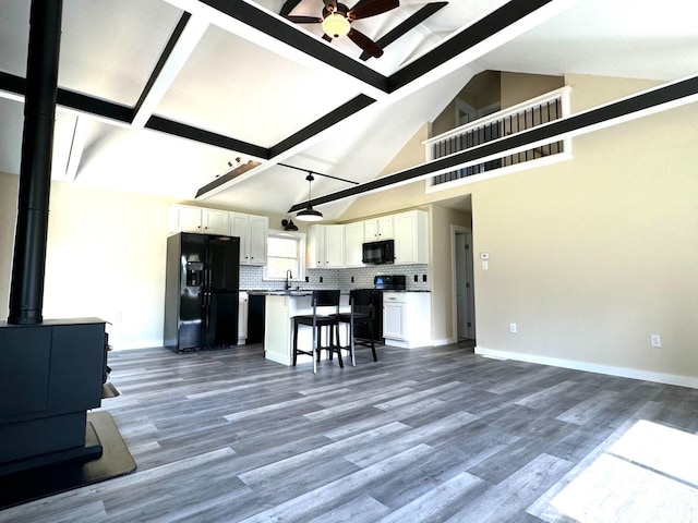 369 Newry Ln, Greenville, NY 12083 - kitchen with black appliances, ceiling fan, open floor plan, a wood stove, and beam ceiling