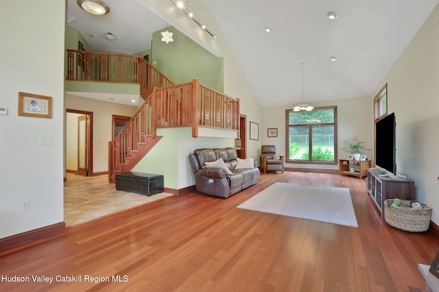 374 Linderman Ave, Kingston, NY 12401 - living area with high vaulted ceiling, light wood-style flooring, stairway, and a chandelier