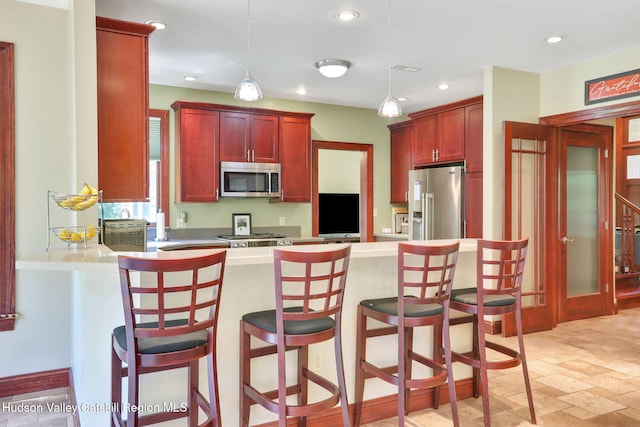 374 Linderman Ave, Kingston, NY 12401 - kitchen featuring appliances with stainless steel finishes, a peninsula, dark brown cabinets, light countertops, and recessed lighting