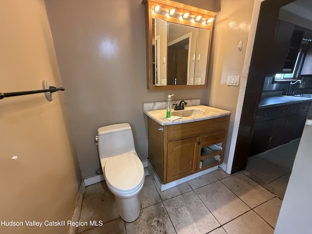 bathroom featuring vanity, toilet, baseboards, and tile patterned flooring