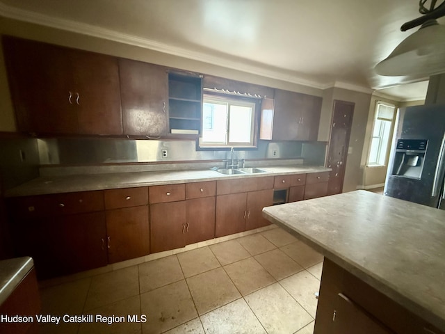 kitchen featuring light tile patterned floors, plenty of natural light, light countertops, and a sink