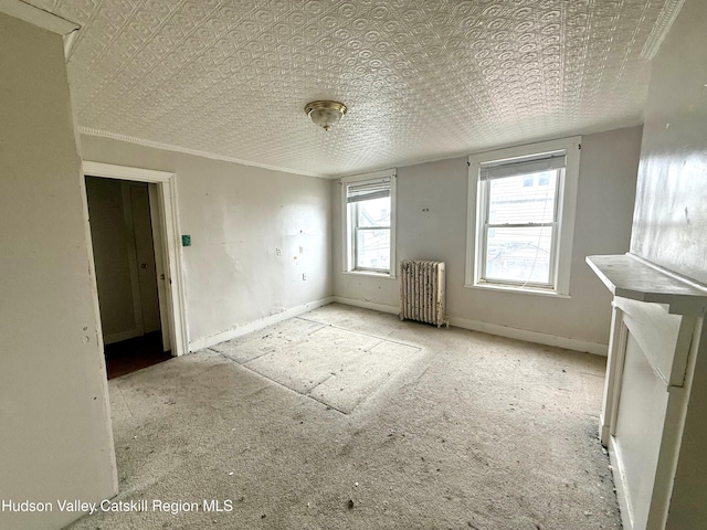 empty room featuring radiator and baseboards