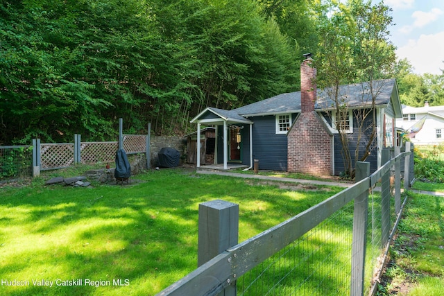 view of front of property with fence private yard, a chimney, and a front lawn