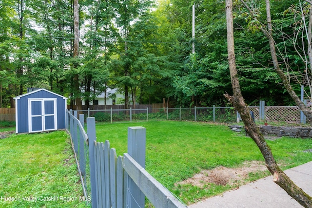 view of yard featuring a fenced backyard, a shed, and an outbuilding