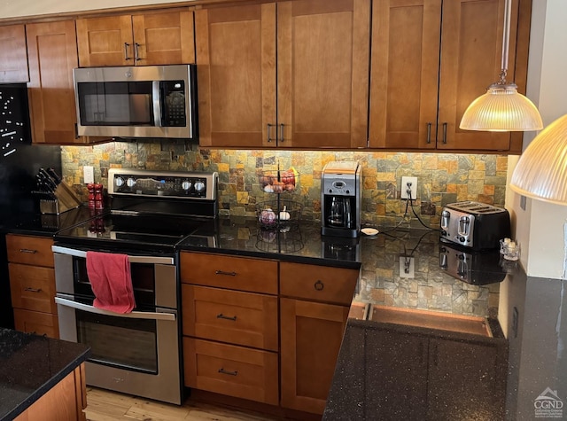 108 Brainard Ridge Rd Unit 14B, Windham, NY 12496 - kitchen with appliances with stainless steel finishes, brown cabinetry, dark stone counters, decorative backsplash, and light wood-style floors
