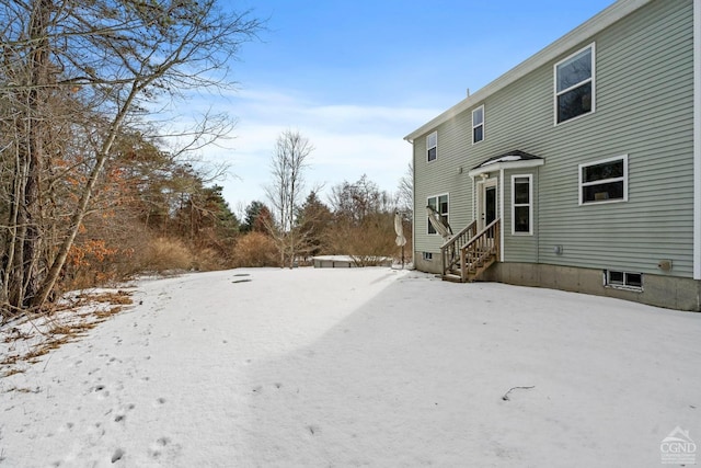 snow covered house featuring entry steps