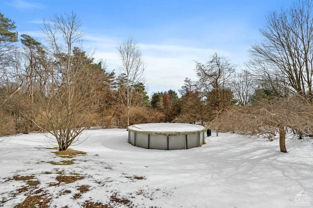 snowy yard featuring a covered pool