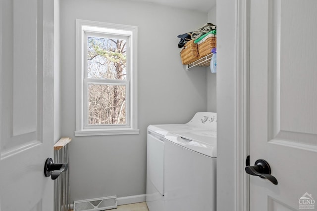 clothes washing area with washing machine and dryer and baseboards