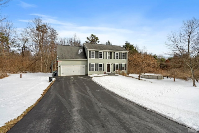colonial house featuring an attached garage and driveway