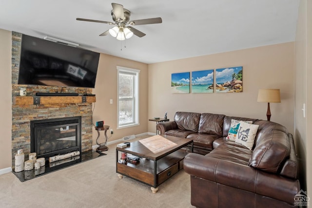 carpeted living room with ceiling fan, a fireplace, and baseboards