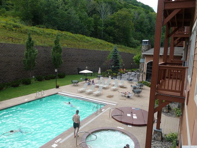 62 Liftside Dr Unit 306F1, Hunter, NY 12442 - community pool featuring a patio area, fence, and a view of trees