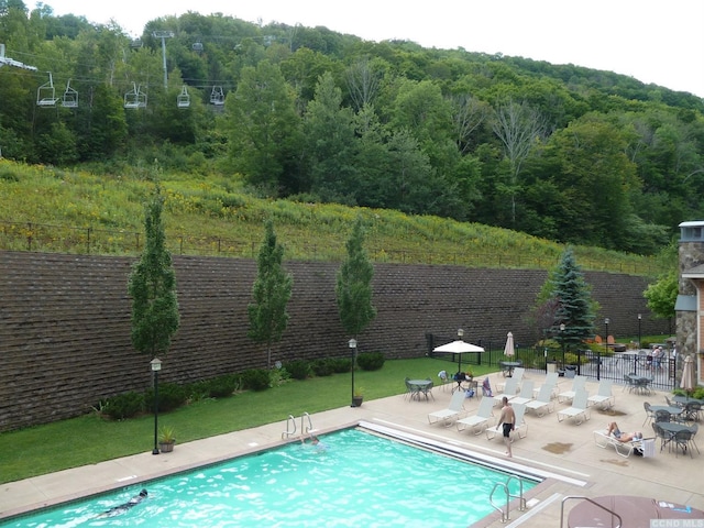 62 Liftside Dr Unit 306F1, Hunter, NY 12442 - view of pool with fence, a view of trees, and a patio