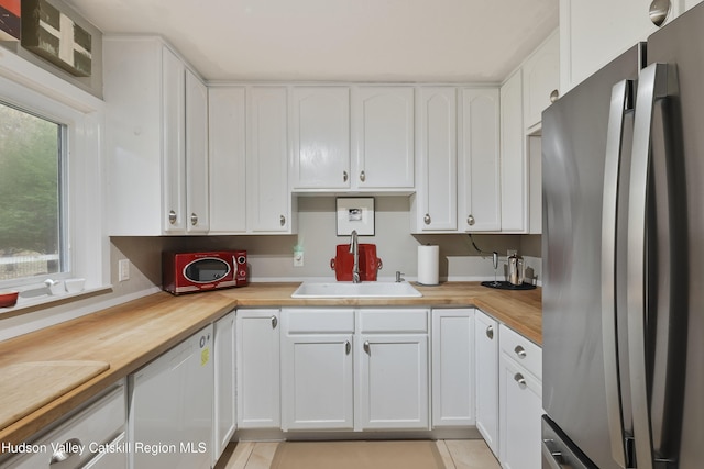 33 Cottonwood Ln, Woodstock, NY 12498 - kitchen featuring freestanding refrigerator, dishwasher, wood counters, white cabinets, and light tile patterned floors