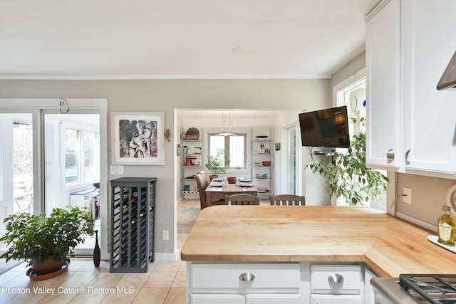 33 Cottonwood Ln, Woodstock, NY 12498 - kitchen featuring butcher block countertops, light tile patterned floors, white cabinets, and a peninsula
