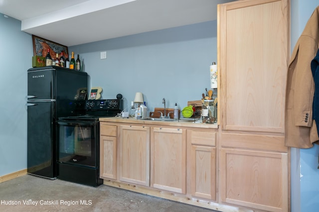 kitchen with light brown cabinets, unfinished concrete flooring, light countertops, black appliances, and a sink